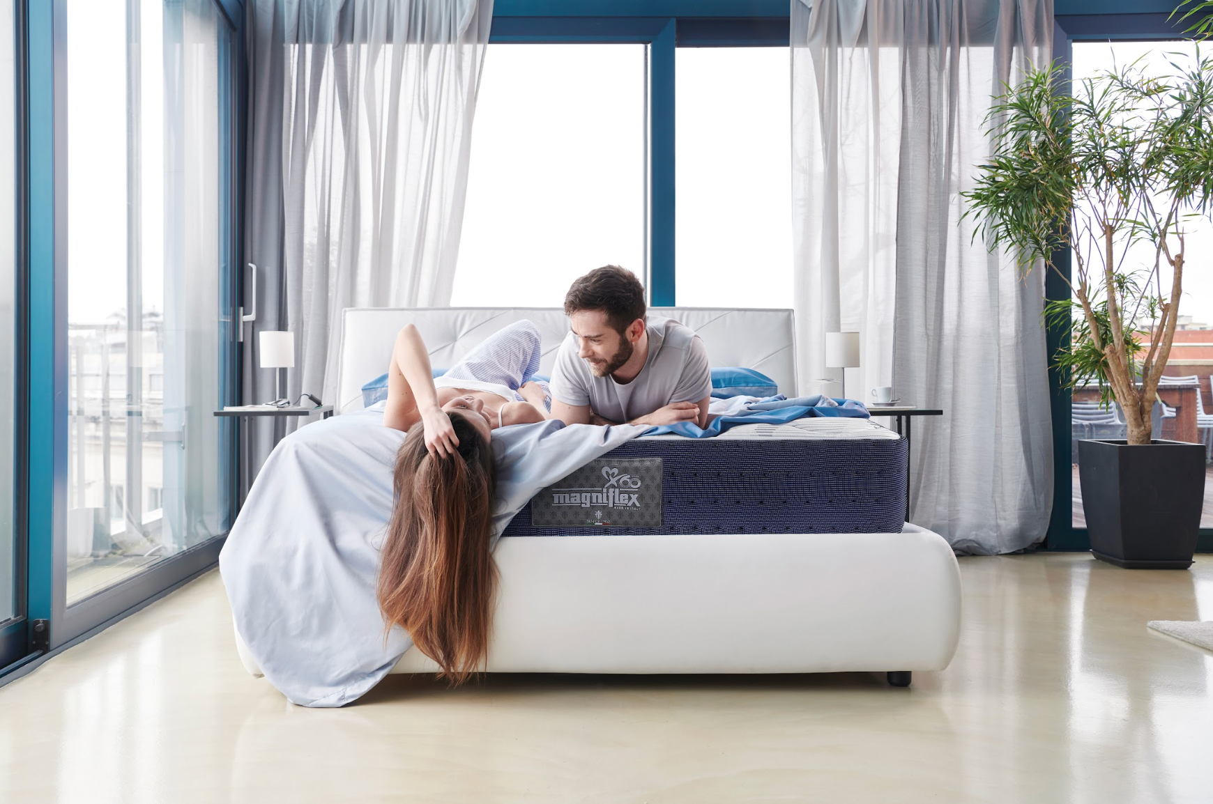 A couple laying in a Magniflex mattress inside a hotel