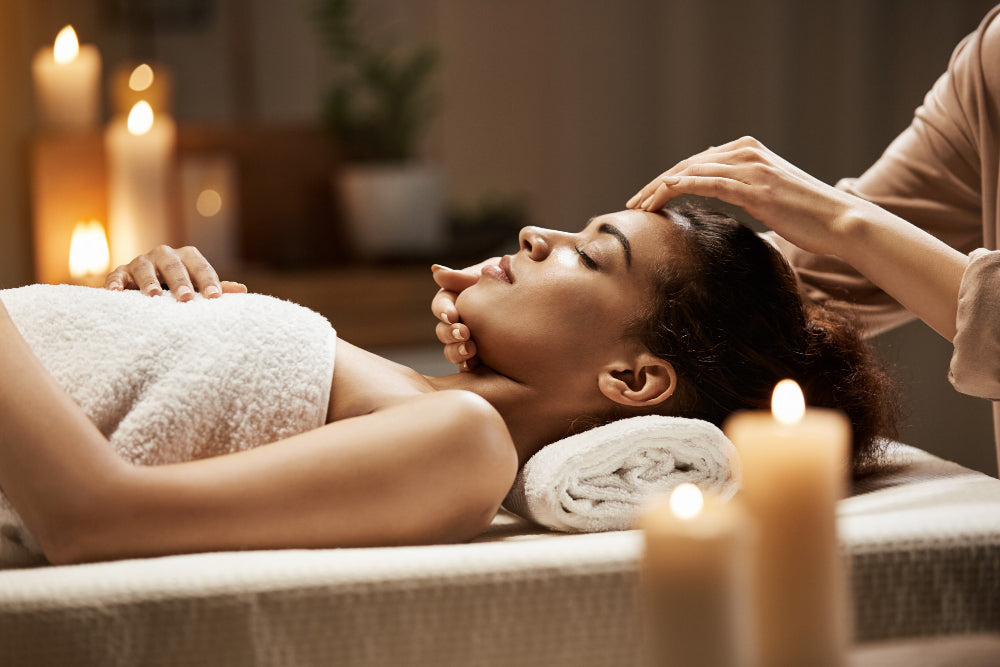 A woman lying down on a massage table getting a relaxing treatment from a luxury spa in Dubai.