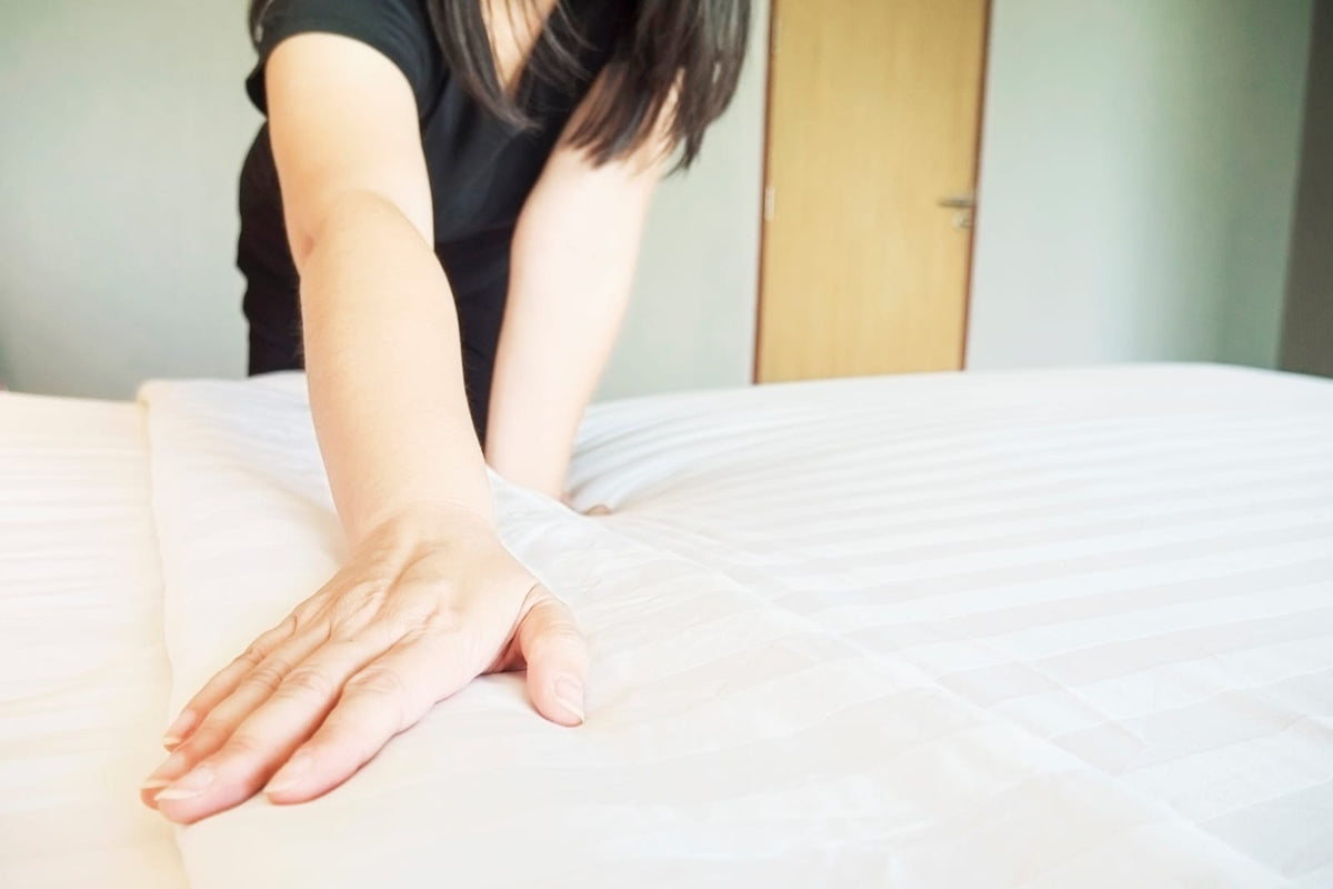 Woman testing her mattress firmness to achieve better rest. 