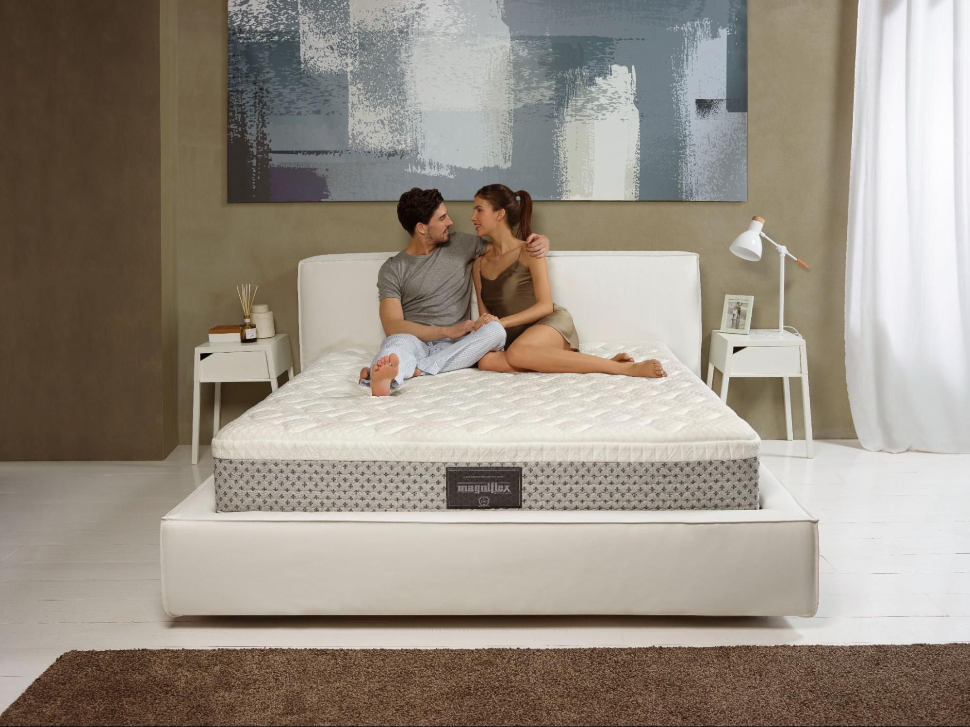A queen size bed from Magniflex with a couple enjoying its comfort and quality for restful sleep and a stylish bedroom setup.