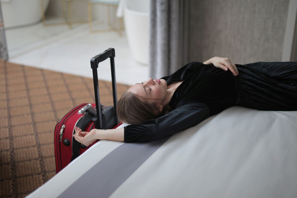 Woman lying down on the bed, tired from jet lag.