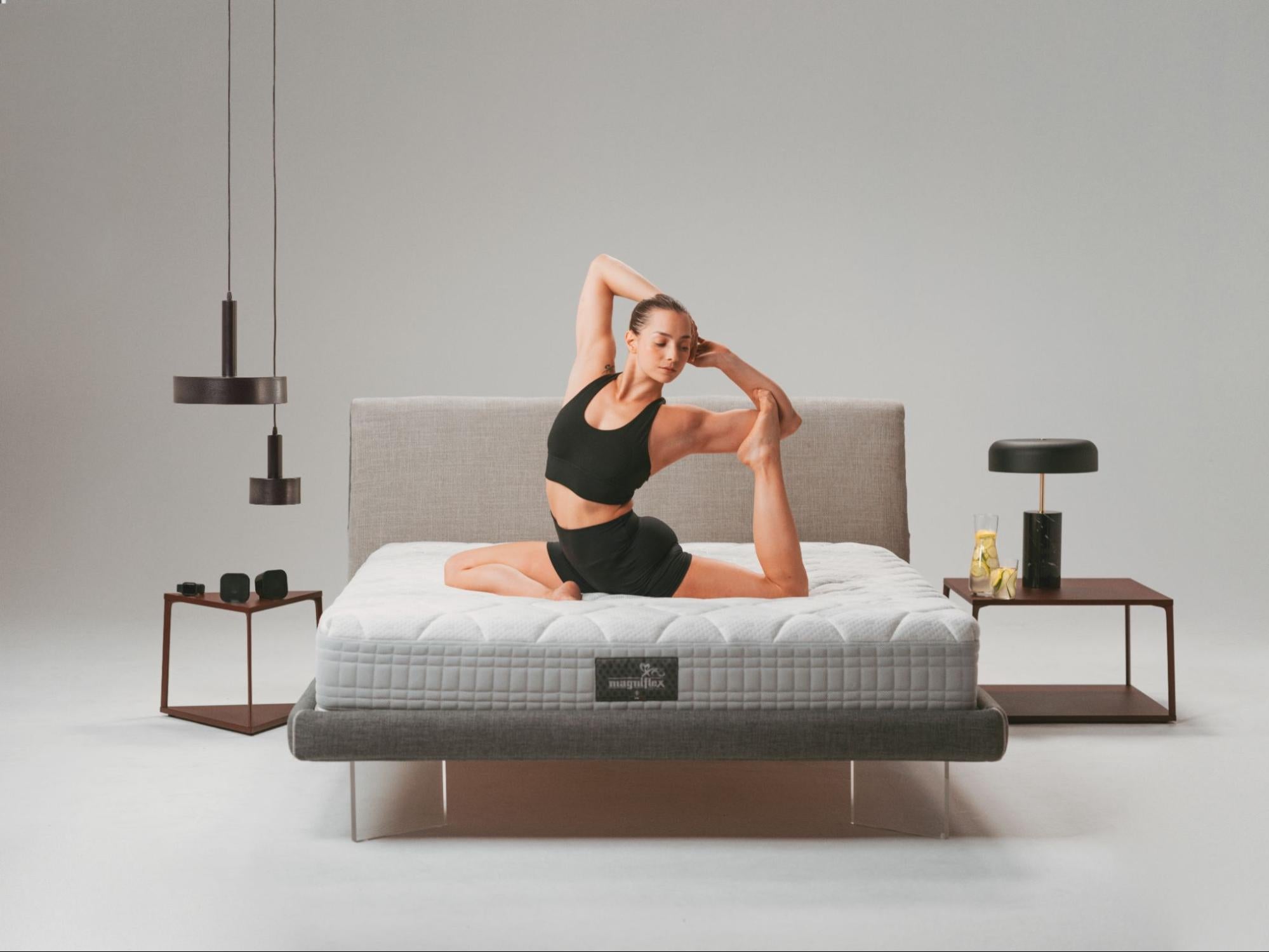 A woman stretching on a Magniflex mattress, representing relaxation with the best mattress in Dubai, UAE for better sleep