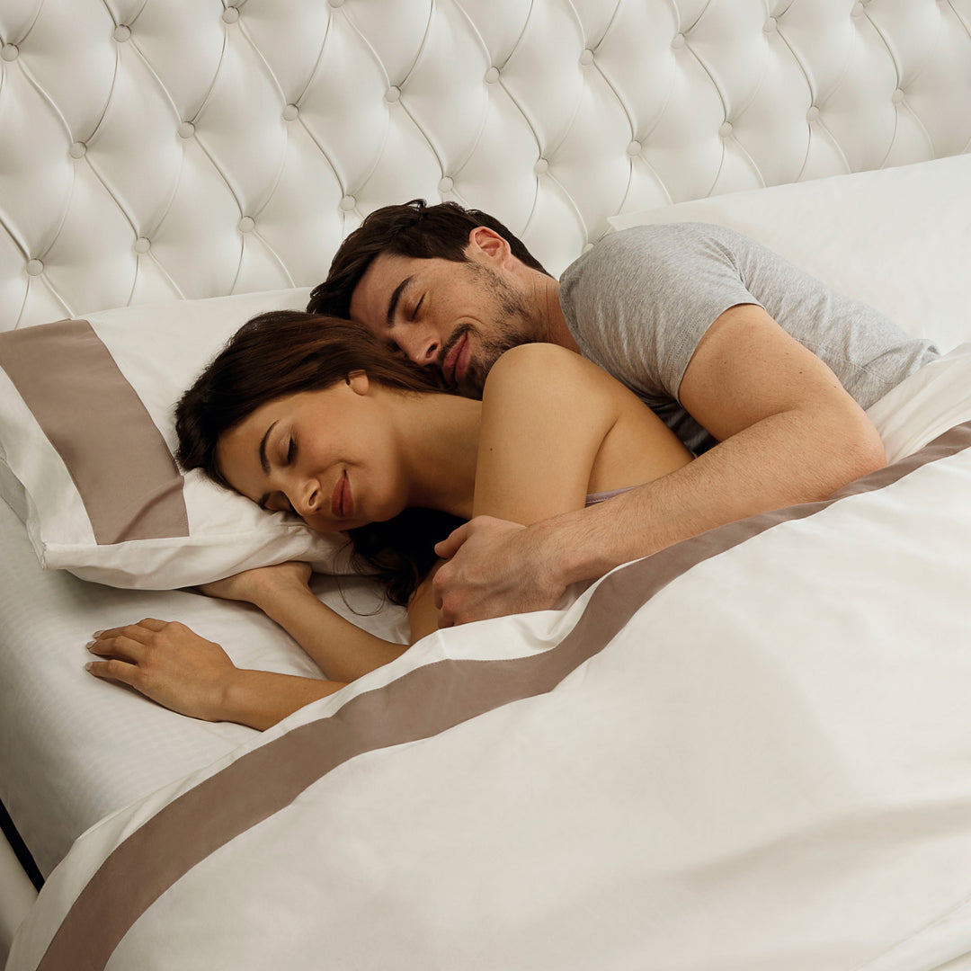 A couple cuddling on a Magniflex queen-size mattress